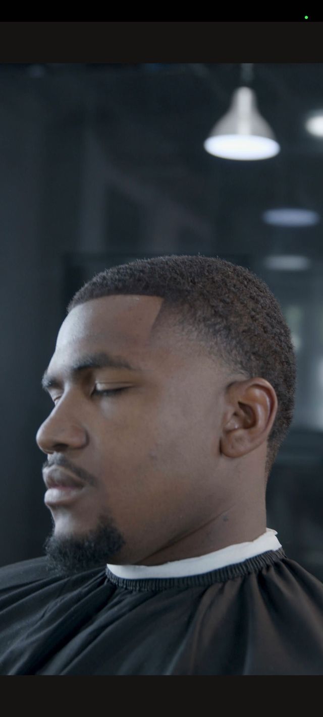 A finished skin fade in profile beneath a pendant light