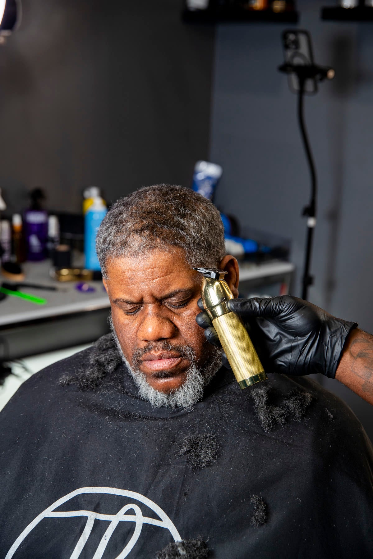 A gold trimmer shaping the line of a silver beard
