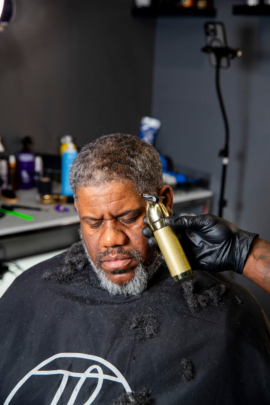 A gold trimmer shaping the line of a silver beard
